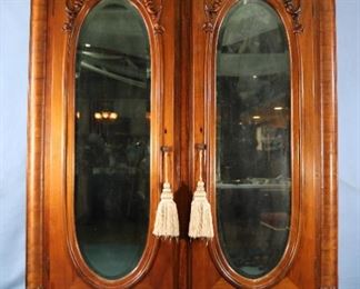 82 - Walnut Victorian 2 door wardrobe with oval mirrored doors, claw feet and carved crown, ca. 1880, 82 in.T, 55 in.W, 24 in. D.