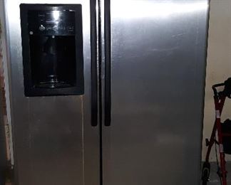 stainless steel side by side refrigerator, working like new plastic coating still on it. ice and water  