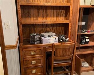1980s Craftsman style oak desk with hutch and chair from the Young-Hinkle Windjammer collection. The desk has a brown leatherette top and features three stacked drawers beside a kneehole with a single drawer above; the drawers have brass pulls and are lined in faux newspaper. Desk measures 44.5" W x 30.0" H x 20.0" D. Hutch measures 44" W x 46" H x 10" D. Photo 1 of 2.