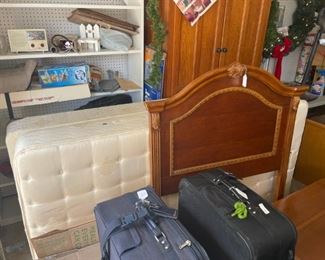 A vintage twin size headboard with a metal frame, mattress, and box spring