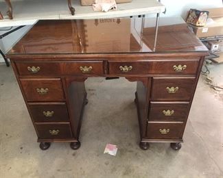 A really nice vintage desk with a glass top in the garage.