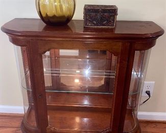 Lighted display cabinet with curved glass sides & glass shelf.