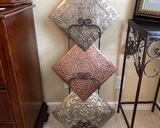 Metal plate rack holding 3 decorative plaques.