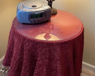 Round accent table with glass and tablecloths.