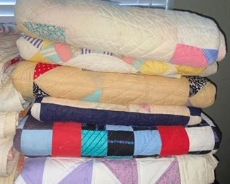 Several quilts—both vintage and newer, most hand stitched, varying condition.