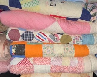 Several quilts—both vintage and newer, most hand stitched, varying condition.