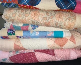 Several quilts—both vintage and newer, most hand stitched, varying condition.