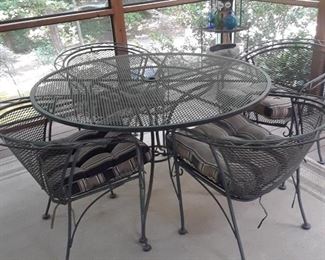 More porch furniture--armchairs and round table in wrought iron