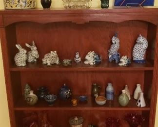Close-up of collectibles including pottery collection and small animals
