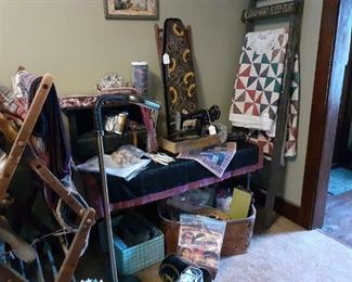 Quilt, vintage hooked ironing board cover, vintage Singer sewing machine, assorted craft materials.