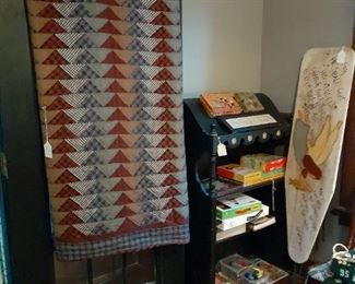 Quilt, children't games, storage shelf, painted ironing board.