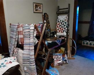 Rugs, drying rack, sewing items, quilt on wooden wall ladder, vintage Singer sewing machine.