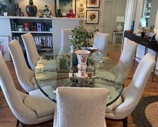 Oval Glass Dining Table with Linen Upholstered Chairs.  Wood bases.  Assorted Artwork.
