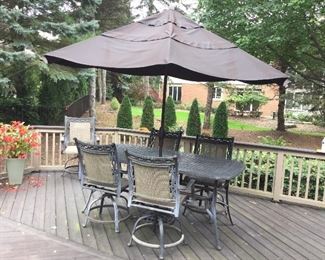 BLACK CAST ALUMINUM BASKET WEAVE PATTERN PATIO TABLE W/6 SWIVEL CHAIRS & UMBRELLA  W/2 MATCHING ARM CHAIRS W/OTTOMANS & COCKTAIL TABLE