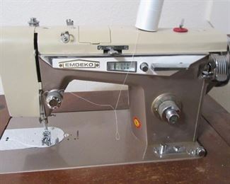 Sewing machine with cabinet and attachments.