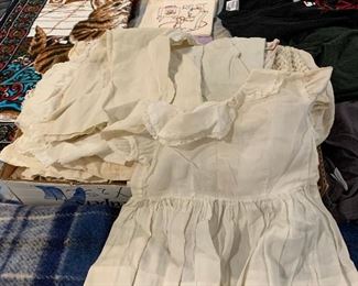 Box full of antique and vintage baby dresses.