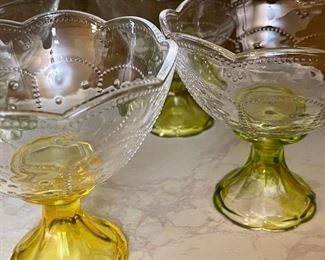 Vintage Depression Glass Ice Cream Dessert Bowls Dessert With Yellow flared stems, olive colored stems and clear stems. Measurements: 5" tall and 5" wide. A dot design embossed on the top.