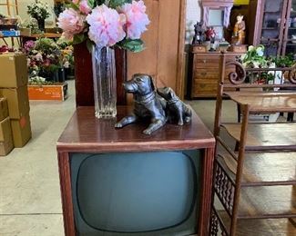 1960s television, dog statue, lots of vases and floral stems