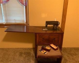 Kenmore sewing machine in cabinet with stool in basement comes with buttonhole attachments