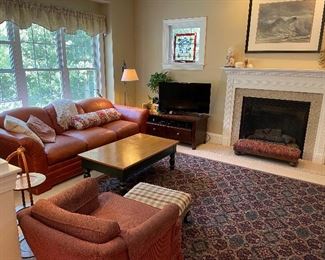 Country style coffee table w/drawer, SOLD - leather sofa, newer tv stand w/open storage & 2 drawers, in dark stain (TV not for sale), wrought iron bridge lamp with new linen shade, upholstered designer FP long stool, framed original signed watercolor of waves, upholstered club chair, ottoman, muffineer, room sized rug.