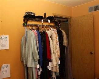 Handmade Vintage Woman's Clothing w/ Vintage hats on top of rack