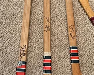 Vintage Cooper mini wood souvenir hockey sticks, signed, and a mini U of M Mariucci Arena souvenir hockey stick