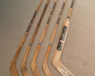 Vintage Northland hockey sticks, including one signed by staff and players as a retirement gift