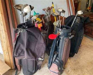 Tons of golf bags and golf clubs