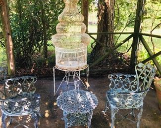 beautiful wrought iron patio furniture and a huge bird cage