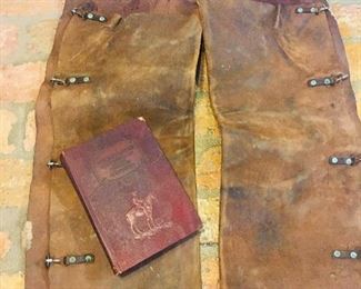 early leather chaps and a very early leather bound book on the Texas Rangers