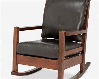 1045
A Gustav Stickley Oak Rocking Chair, No. 2603
First-quarter 20th Century; Eastwood, NY
The oak ladder back rocking chair with four back cross rails over a black leather seat and back cushion atop four square legs with rockers
36" H x 25" W x 31" D
Estimate: $600 - $800