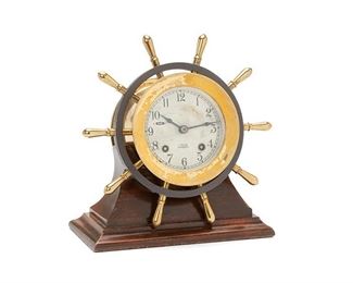 1060
A Chelsea Ship's Bell Clock
First-quarter 20th Century
Dial signed: Chelsea Ship's Bell / Retailed by: Shreve Crump & Low Co. Boston; Serial number: 780885
The polished brass case with ship's wheel surround, silver dial with black Arabic numerals, outer minute-track, eight-day two train movement, strikes on the hour and a half, wheel adjustment for slow/fast, lever for silence, on custom wood base
9" H x 8.5" W x 3.5" D; Dial 3.75" Dia.
Estimate: $500 - $700