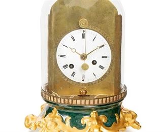 1103
A Continental Dome Clock
First-quarter 19th Century
The white dial with black Roman numeral hour markers and outer minute track and eight-day crown escapement movement with rare cowtail pendulum, on brass and gilt-porcelain base
10.5" H x 8" W x 8" D; Dial: 3.75" Dia.
Estimate: $600 - $800