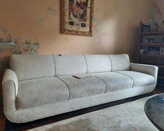 Custom-made early 1950s 9-foot sofa designed and made in NYC with NEW textured white upholstery.  Unique "floating" form on a wooden plinth - rounded arms = glamour and comfort.  Cheaper than IKEA and a bit more interesting.........