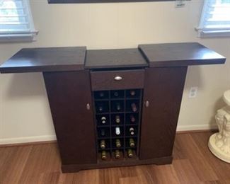 DRY BAR SIDEBOARD WITH EXTENDABLE SERVICE TOP AND 18 BOTTLE STORAGE
$175
