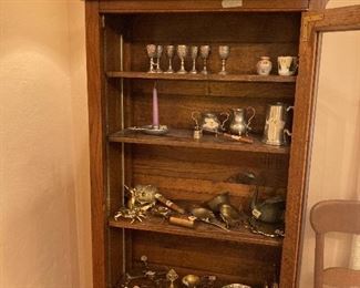 Brass and pewter in great oak cabinet.