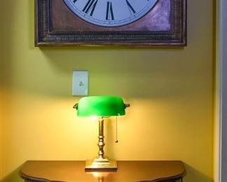 banker's lamp, wall clock, table