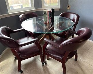 Glass top table with 4 leather chairs on casters