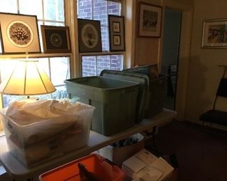 Framed signed art, bins full of home goods/decor 