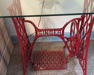 Two tables with singer sewing machine bottoms with glass tops red of course! 