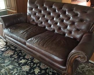 Well loved leather couch and beautiful rug