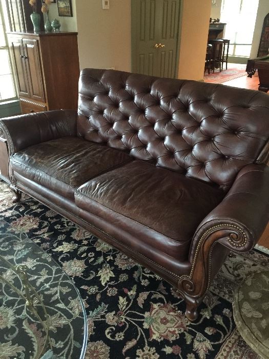 Well loved leather couch and beautiful rug