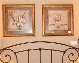 Headboard of bed and pictures above the bed.