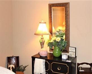 Small chest of drawers, with mirror and decorative items.