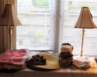 Table is full of placemats, napkins and small linen pieces.