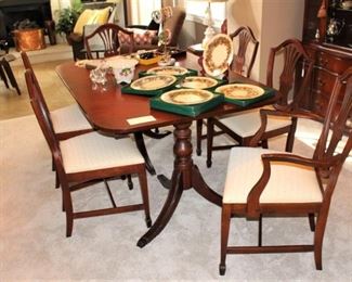 Mahogany table with six chairs.  One of the chairs is an armchair.  Comes with one leaf and protective pads.  