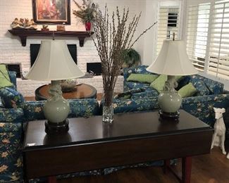 Beautiful drop leaf sofa table, three sofas, coffee table, and lamps.