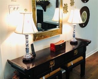 Beautiful sofa table with two benches, porcelain blue and white lamps, stunning gold leaf mirror, and other accessories. 