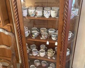 Dozens of mustache cups in an early 20th C. Oak china cabinet