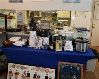 A table full of small kitchen appliances.  The large picture on the left side of the table is "cut-paper" art - super!